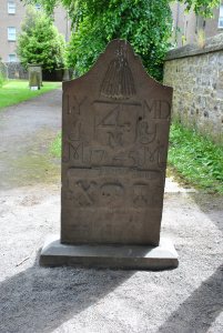 The merchant and candle maker John young dies in 1745, the 4-M is a merchant sign, and a bunch of candles states his trade.